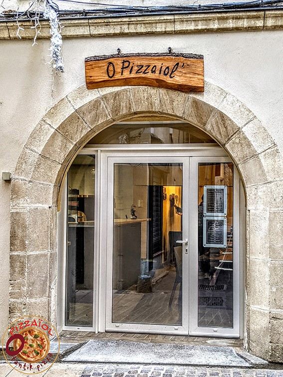 L'arche en pierre et l'enseigne en bois de la pizzeria
