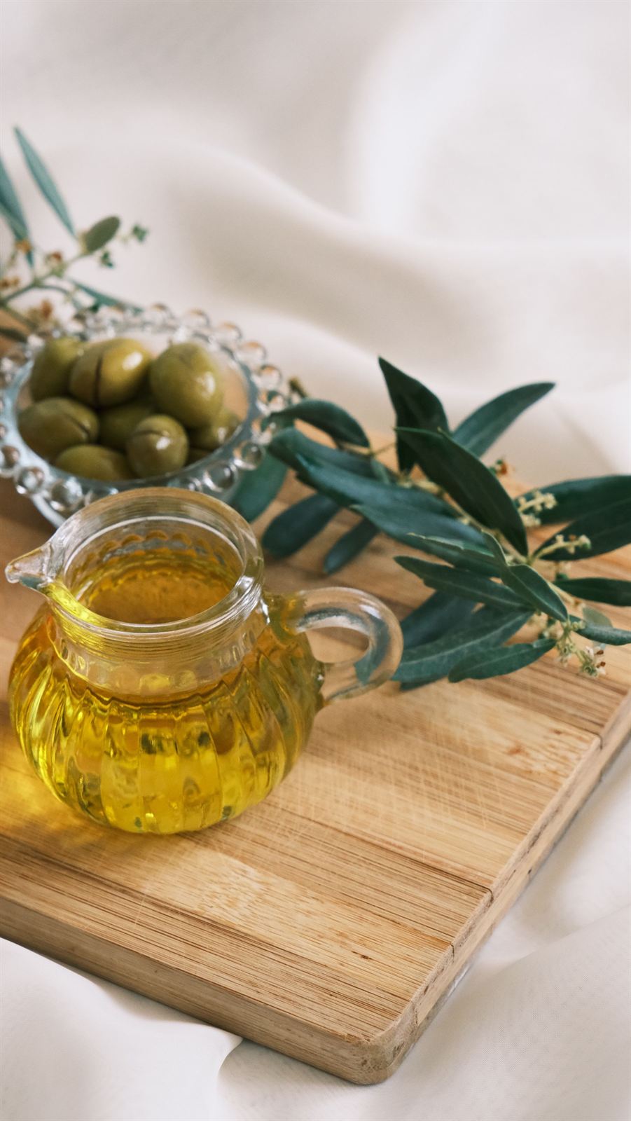 Huile d'olive et olives sur une planche en bois