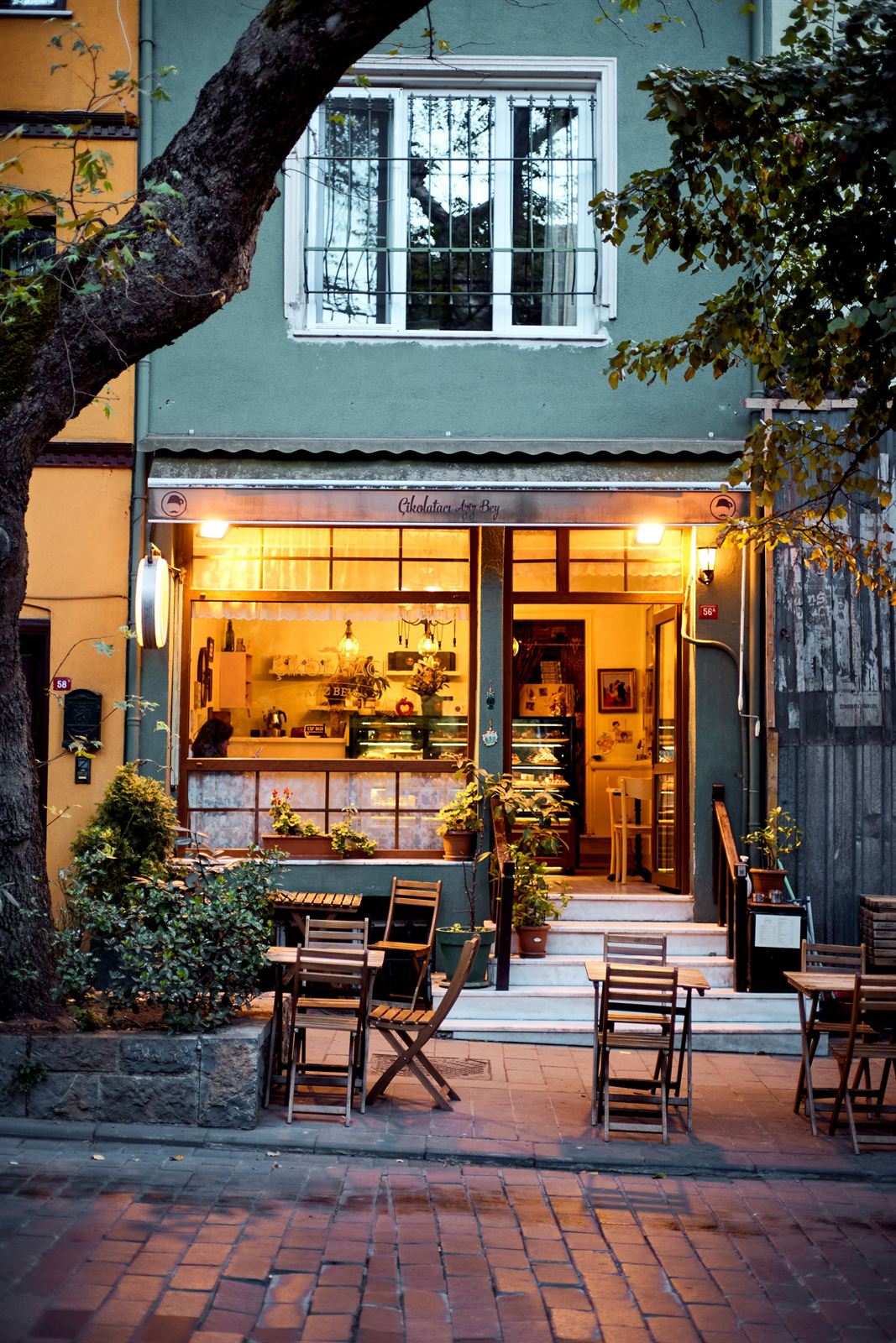 Façade éclairée avec terrasse en soirée